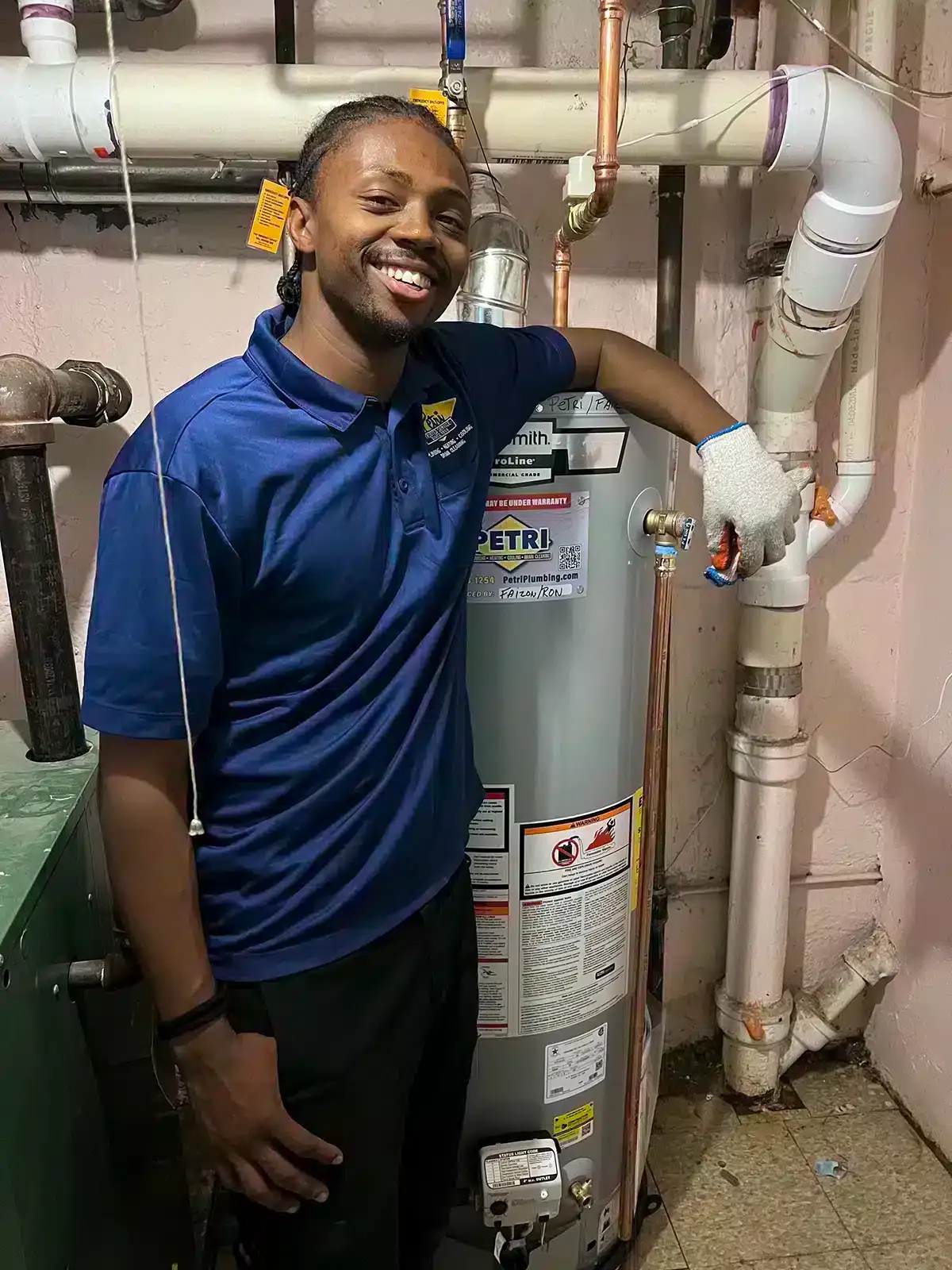 A Petri Technician smiling after installing a new water heater in a Brooklyn, NY home.
