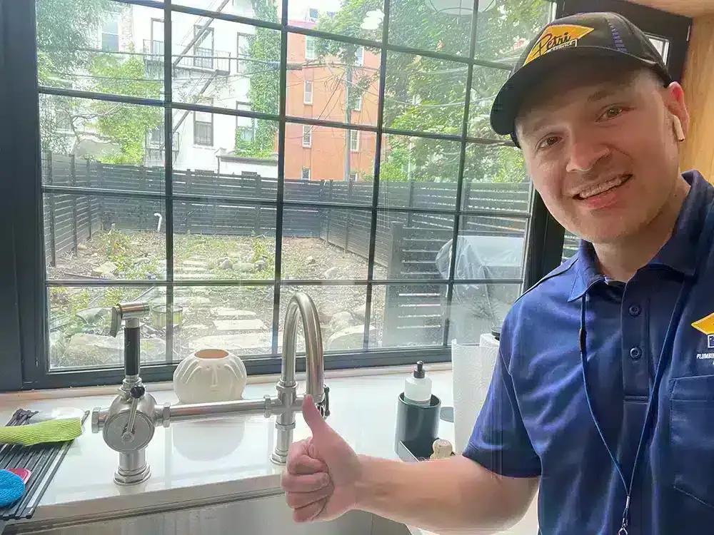 Petri Technician smiling and giving a thumbs up after installing a new kitchen faucet in a Brooklyn, NY home.
